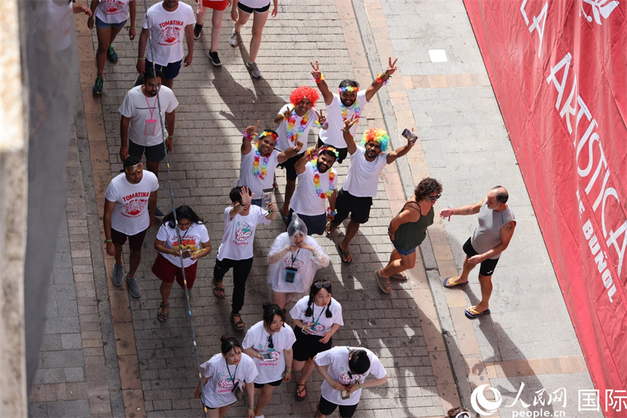 图为各国游客前往“西红柿大战”会场。人民网记者 颜欢摄