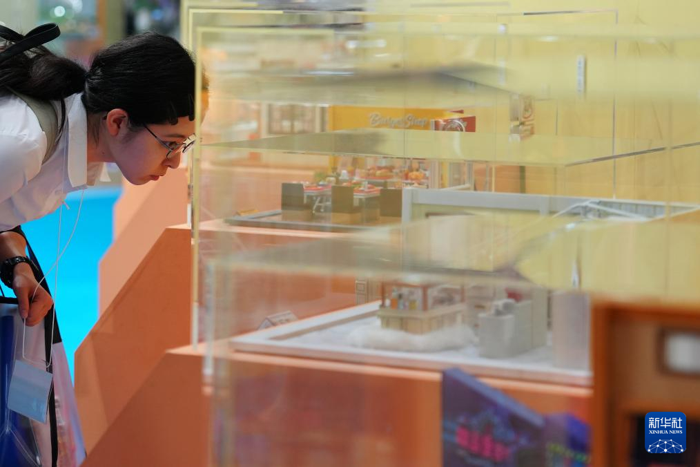 8月28日，一名参观者在日本东京玩具展上参观展出的玩具。新华社记者 贾浩成 摄