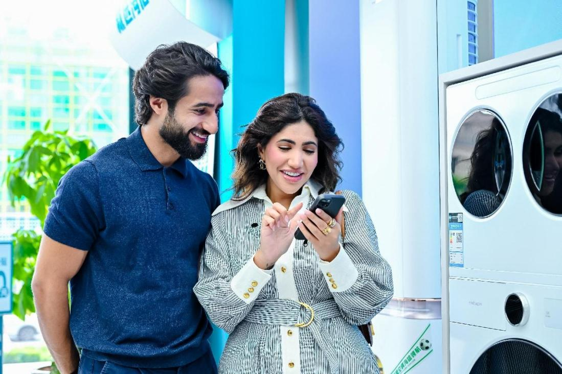 博主在体验手机操作洗衣机。海信供图