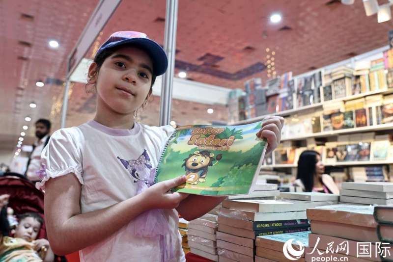 一位小读者展示图书。 人民网 伊纳斯·易卜拉欣摄