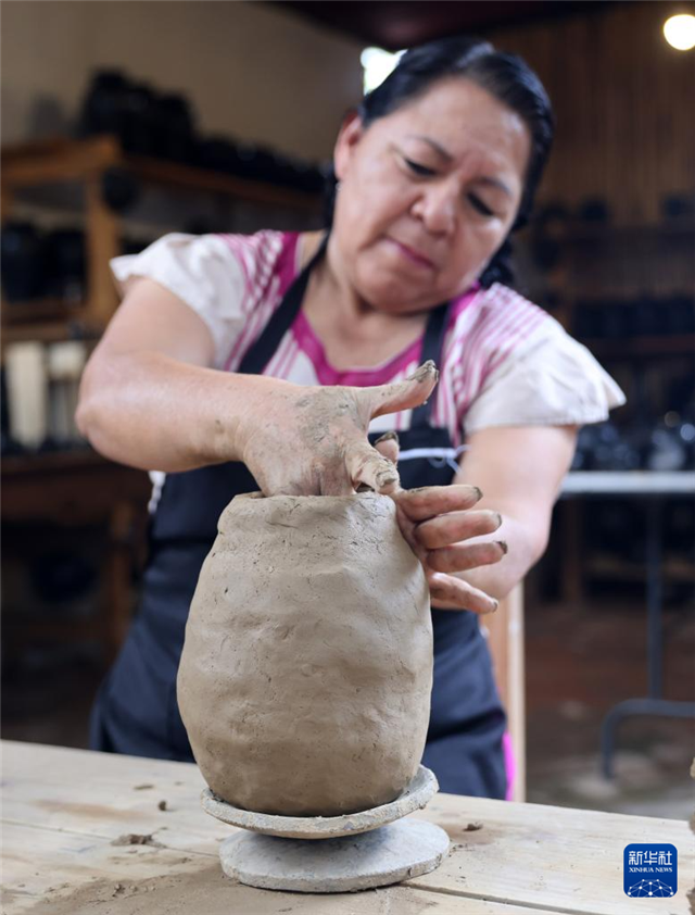 9月14日，在墨西哥瓦哈卡州的圣巴托洛科约特佩克市，一名黑陶手工艺者给陶土塑形。新华社记者 李梦馨 摄