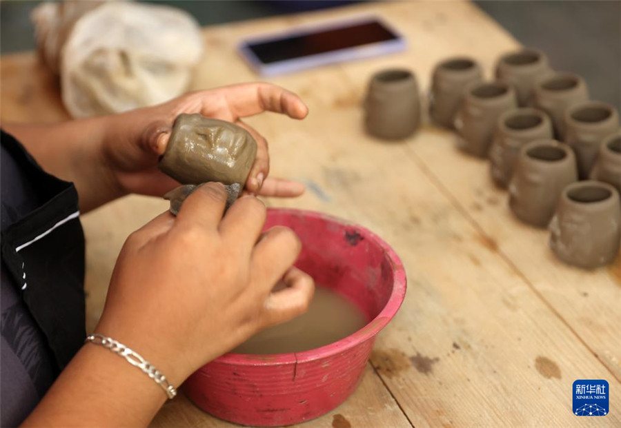 9月14日，在墨西哥瓦哈卡州的圣巴托洛科约特佩克市，一名黑陶手工艺者给陶土塑形。新华社记者 李梦馨 摄
