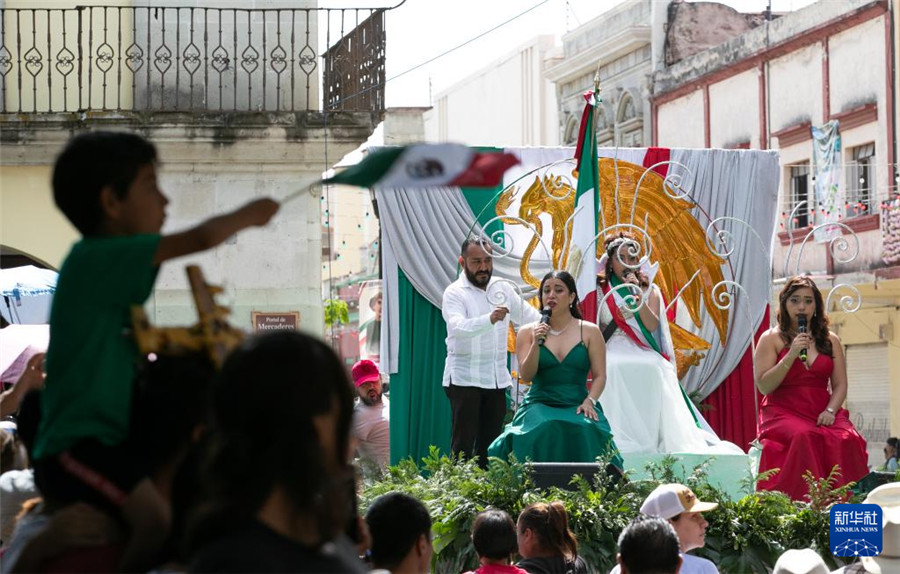 9月16日，在墨西哥瓦哈卡州的瓦哈卡市中心，人们身着国旗颜色的服装进行独立日庆祝表演。新华社记者 李梦馨 摄