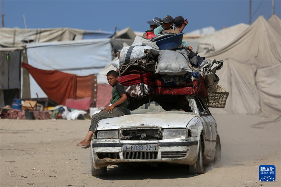 9月18日，在加沙城以西的沿海公路上，儿童与家人一起运载着生活用品，汇入人潮向南撤离。新华社发（里泽克·阿卜杜勒贾瓦德摄）