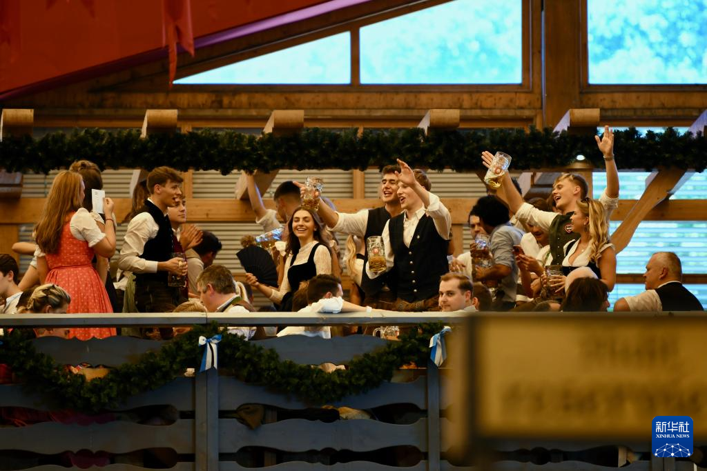 9月20日，人们在德国慕尼黑啤酒节上享用啤酒。新华社记者 张豪夫 摄