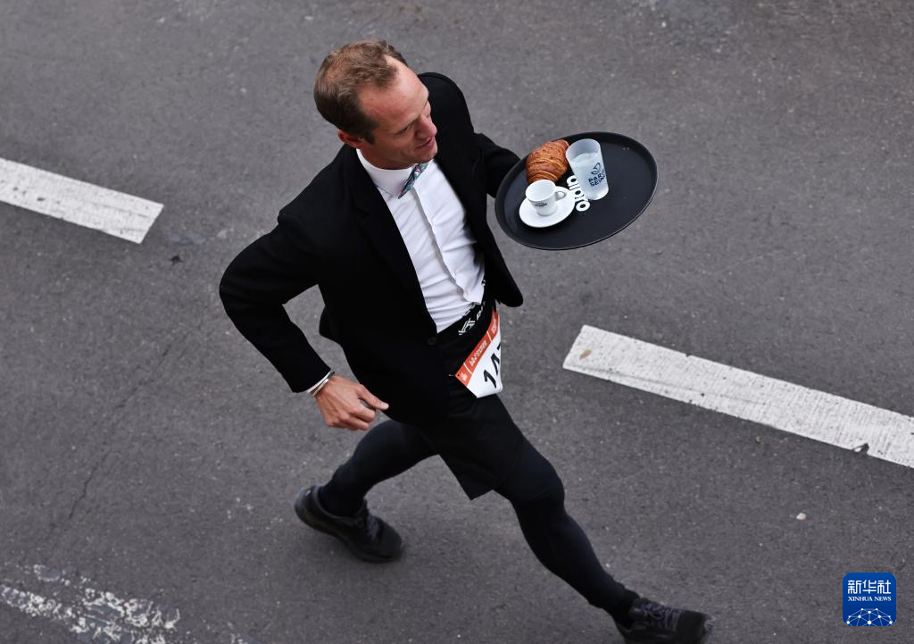 9月21日，参赛者在法国巴黎参加服务员赛跑。新华社记者 高静 摄