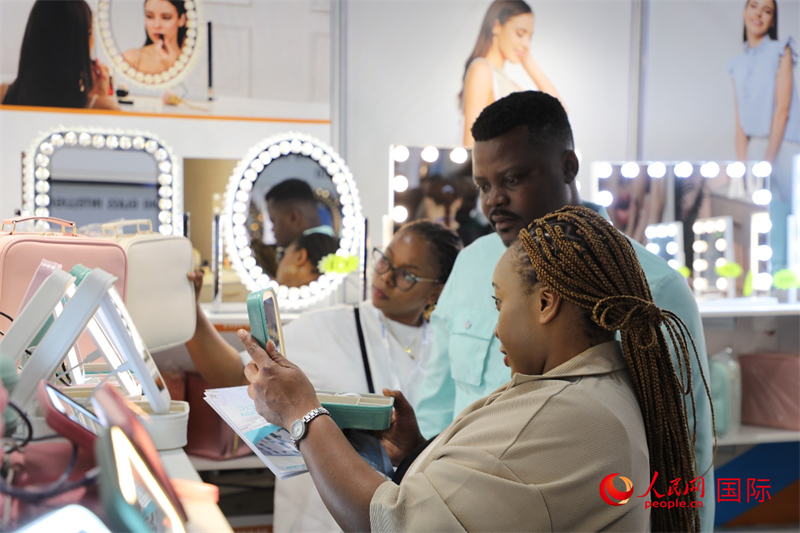 在第九届中南贸易博览会上,参观者在体验中国化妆镜产品。人民网记者 戴楷然摄
