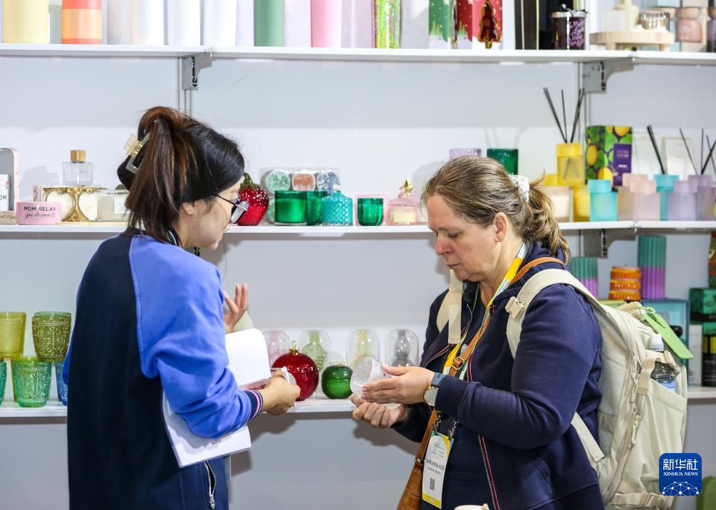 9月25日，在澳大利亚悉尼，一名参会者（右）在第二届中国消费品（澳大利亚）品牌展上咨询商品。新华社记者 马平 摄