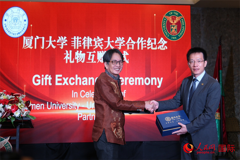 厦门大学副校长史大林与菲大迪利曼校区前校长陈万杰代表两校互赠纪念礼物,以志久谊。人民网记者 樊帆摄