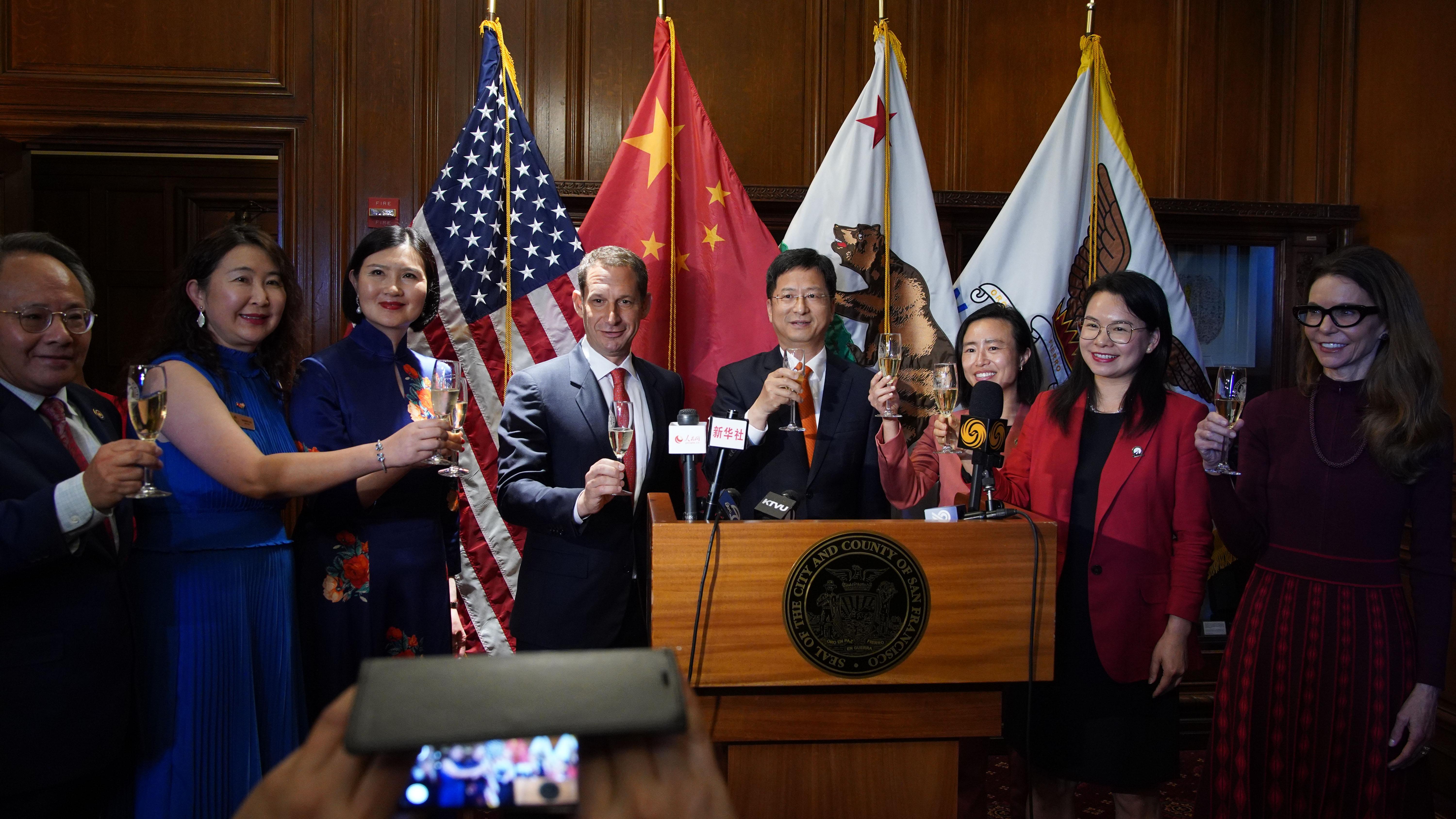 在旧金山市政厅,中国驻旧金山总领事张建敏(右),与旧金山市长丹尼尔·罗里(左中)一起举杯,与参加升旗仪式的嘉宾庆祝中华人民共和国成立 76 周年。谢为人摄