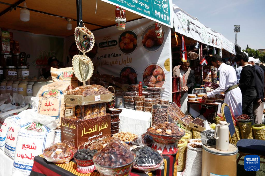 10月6日，在也门首都萨那，人们在展会上购买各种枣类。新华社发（穆罕默德摄）