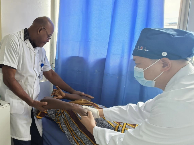 梁医生正在为患者进行中医手法复位。中国援赤几医疗队供图