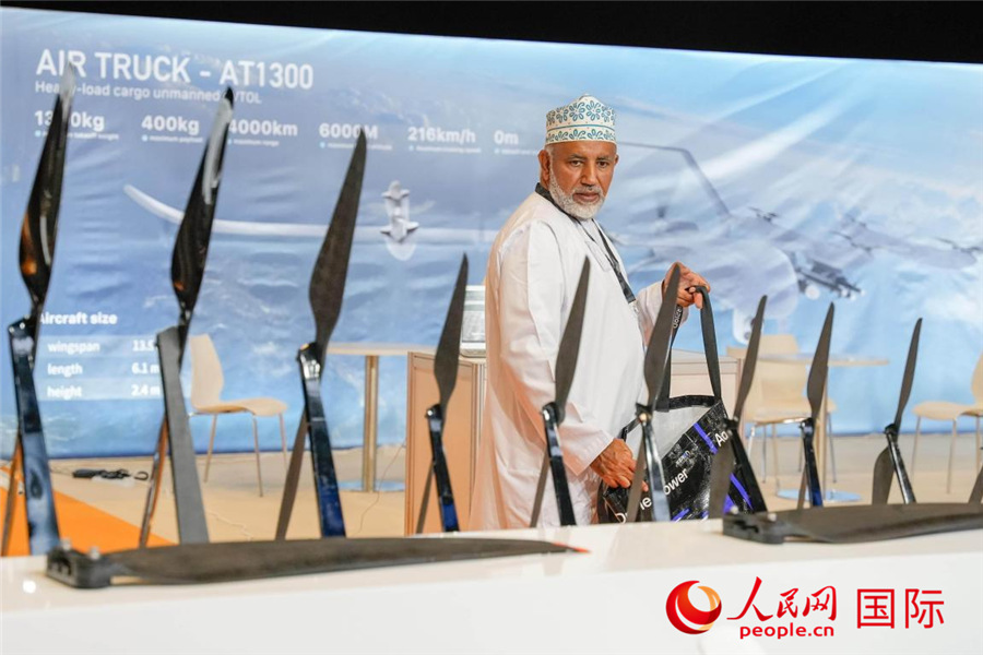 一名观众走过无人机旋翼展台。人民网 塔里克·易卜拉欣摄