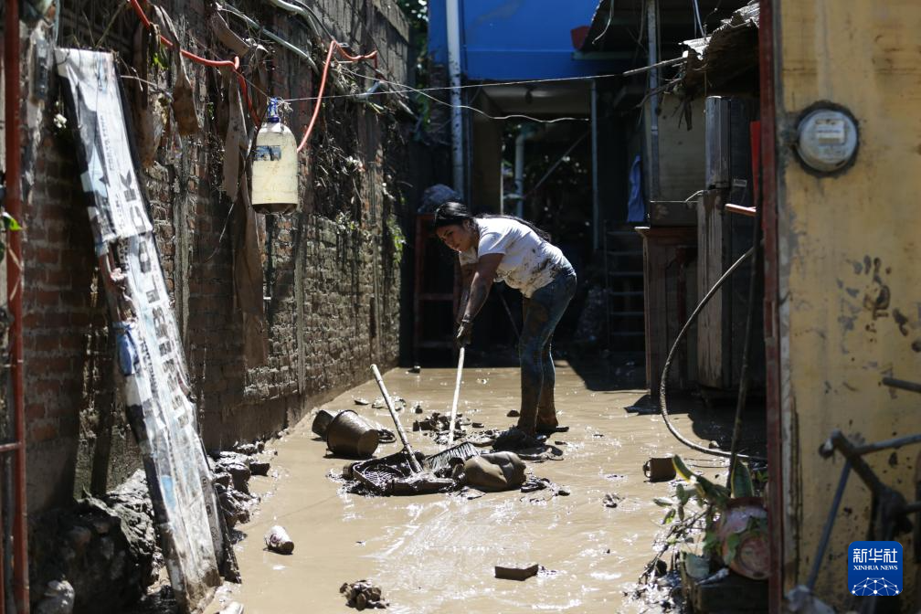 10月12日，在墨西哥韦拉克鲁斯州波萨里卡，一名女子清理房屋前的淤泥。 新华社发（弗朗西斯科·卡涅多摄）