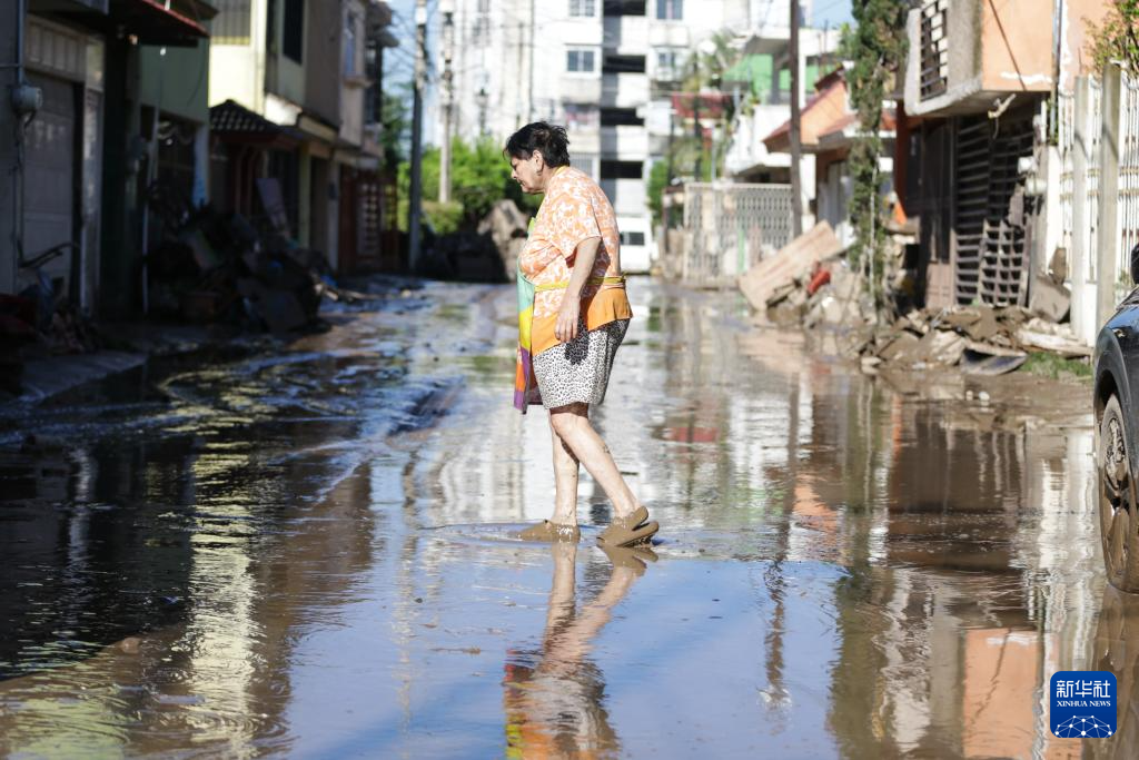 10月12日，在墨西哥韦拉克鲁斯州波萨里卡，一名妇女走过泥泞积水的街道。 新华社发（弗朗西斯科·卡涅多摄）