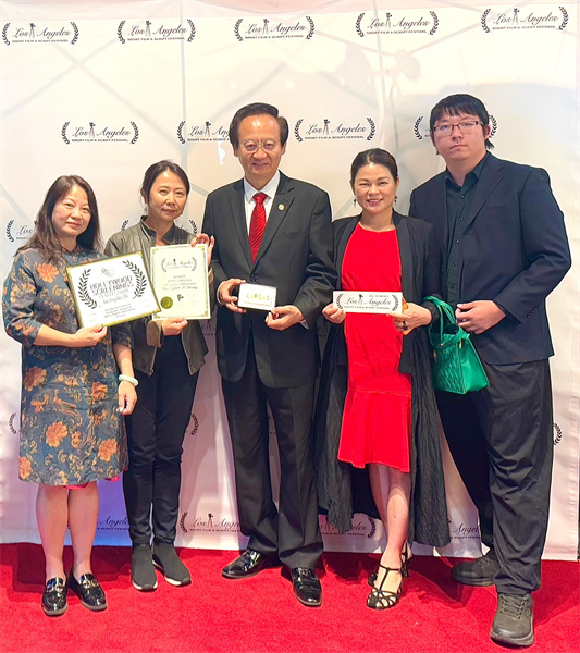 《弦系中西》制片人邓圩(左一)、导演张伟民(左二),主角薛苏里(左三)及主创人员手持奖状在电影节现场合影。黄甦摄