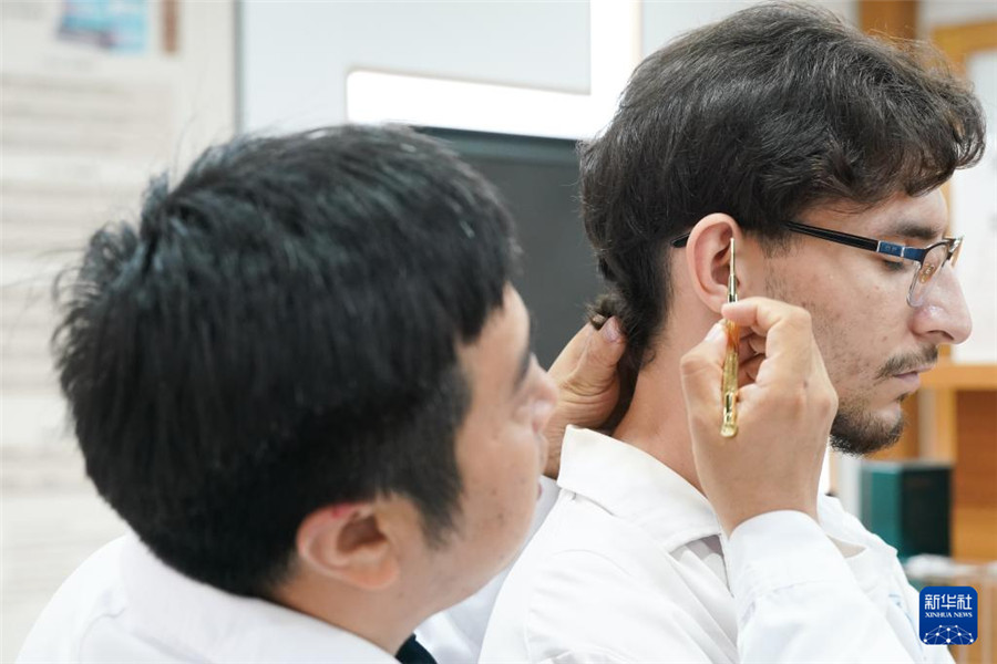 10月16日，安徽中医药大学老师潘银星（左）教学生们认识穴位。新华社记者 杜宇 摄