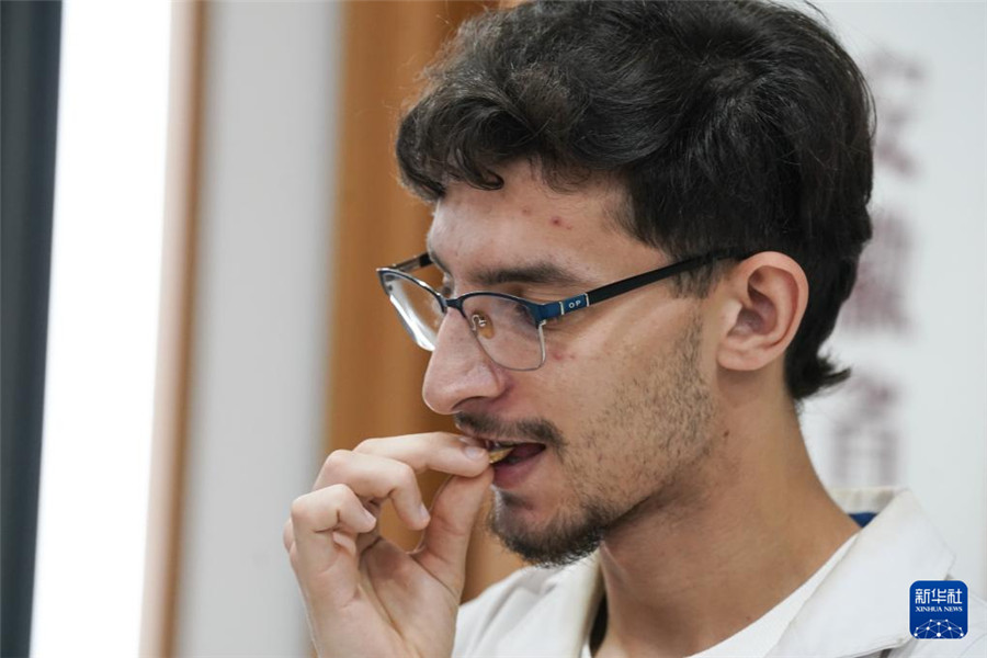 10月16日，来自阿尔及利亚的药学专业大二学生常健安学习辨别中药材黄芪。2024年，在本国学习生物化学的常健安通过考试，获得了来中国系统学习中医学和中草药的机会。新华社记者 杜宇 摄