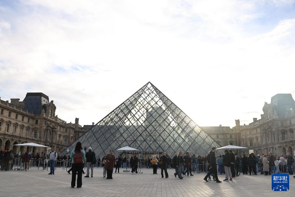 10月22日，在法国巴黎，大量游客聚集在卢浮宫博物馆的玻璃金字塔入口前。新华社记者 张百慧 摄