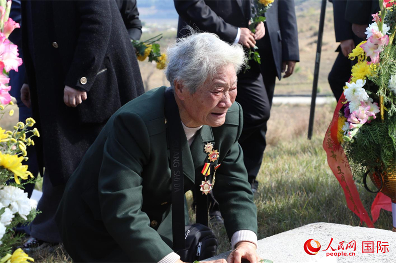 志愿军特等功臣李家发的妹妹李家英向烈士墓祭酒献花。 人民网记者 刘融摄