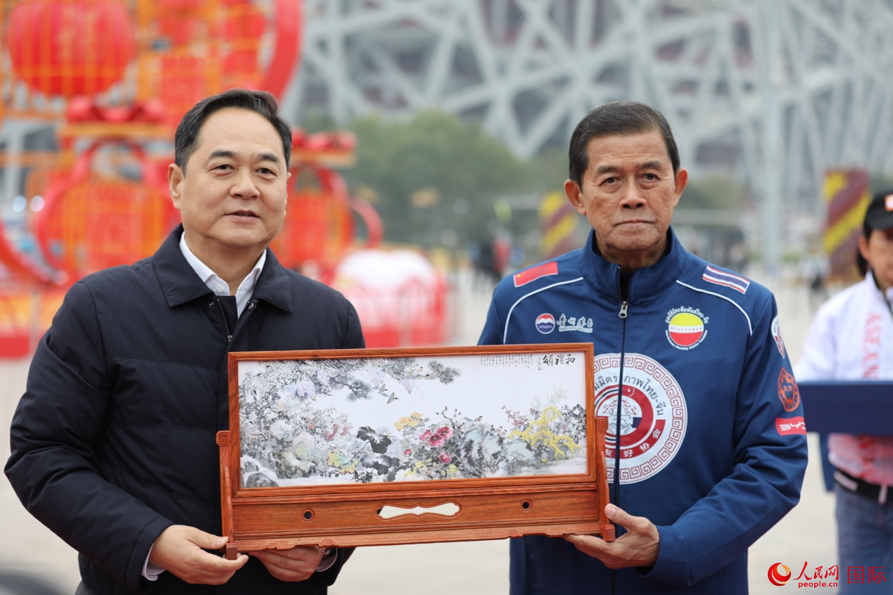 中泰双方在仪式上互赠礼物(左为中国人民对外友好协会会长杨万明,右为泰国前副总理、泰中友好协会会长功·塔帕朗西。人民网记者 贾文婷摄