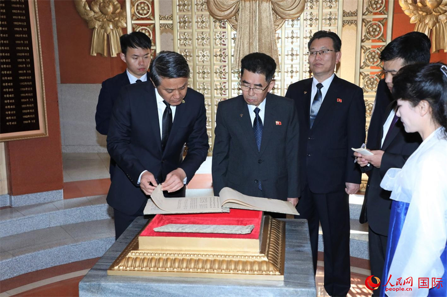 中朝双方人员步入友谊塔塔室,一同瞻仰反映中国人民志愿军抗美援朝、保家卫国以及参与朝鲜战后重建历程的照片、绘画、题词等资料。人民网记者 刘融摄