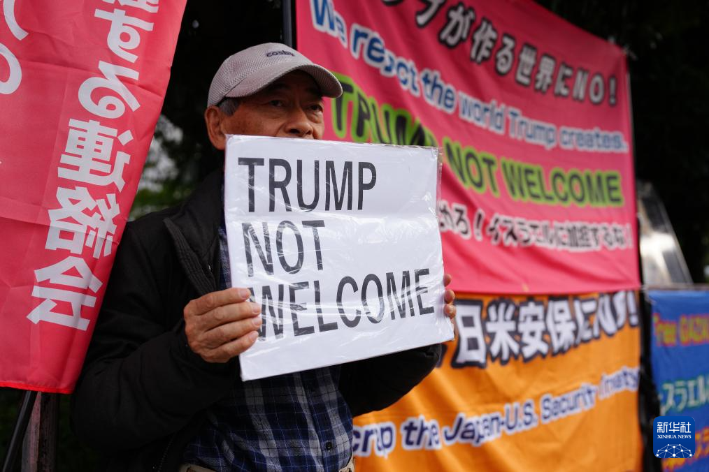 10月28日，在日本东京的首相官邸外，示威者手举标语参加抗议活动。新华社记者 贾浩成 摄