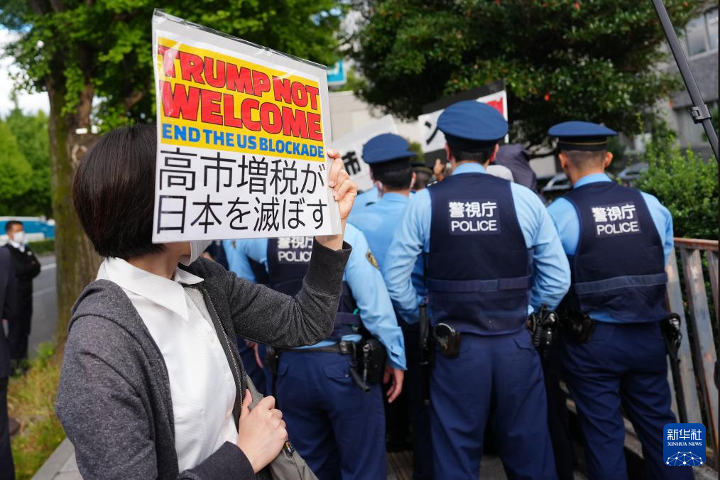 10月28日，在日本东京的首相官邸外，示威者手举标语参加抗议活动。新华社记者 贾浩成 摄