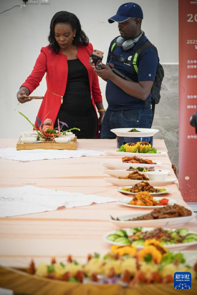 10月30日，在肯尼亚首都内罗毕举行的2025世界中餐非洲大赛上，宾客为出炉的菜品拍照。新华社记者 李亚辉 摄