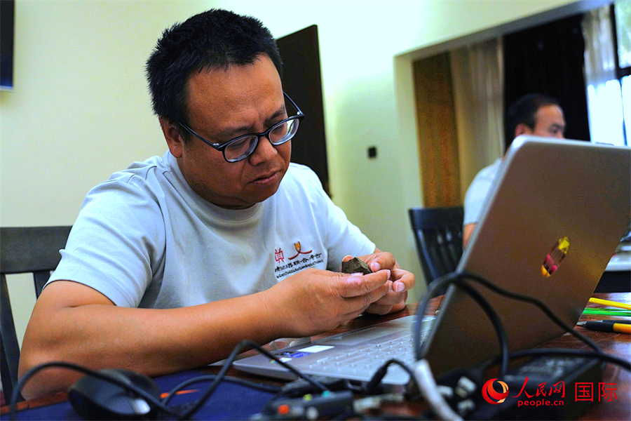 中方队员顾雪军对第10地点出土石制品进行分类整理。人民网记者 黄炜鑫摄