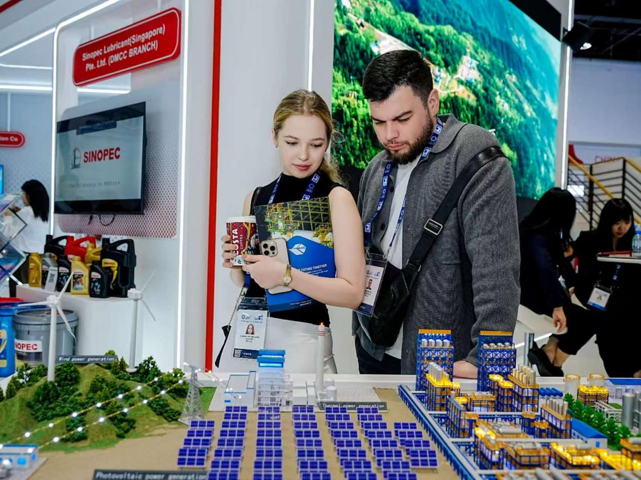 第41届阿布扎比国际石油展期间，与会人士在参观中国石化展出的绿电制氢项目沙盘。主办方供图
