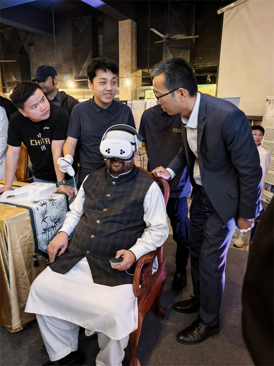 11月7日晚,巴基斯坦国家遗产与文化部部长奥朗则布在中国旅游文化周活动展区体验VR设备。中国驻巴基斯坦使馆供图