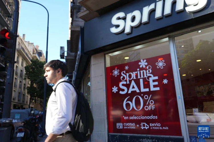 11月14日,市民从阿根廷首都布宜诺斯艾利斯的一家家具店前走过。新华社记者 张铎 摄