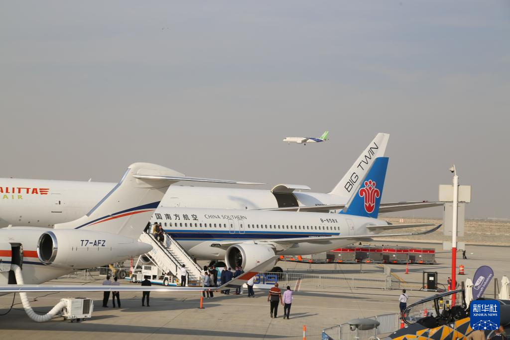 11月17日,在阿联酋迪拜,中国商飞的C919飞机进行飞行展示,地面上停着的是中国南航的C919飞机。新华社记者 温新年 摄