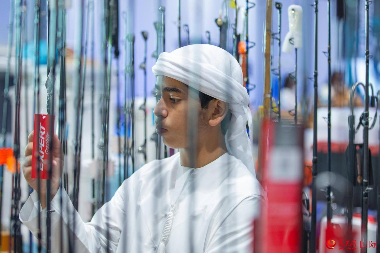 一位小观众在了解钓鱼装备。人民网 塔里克·易卜拉欣摄