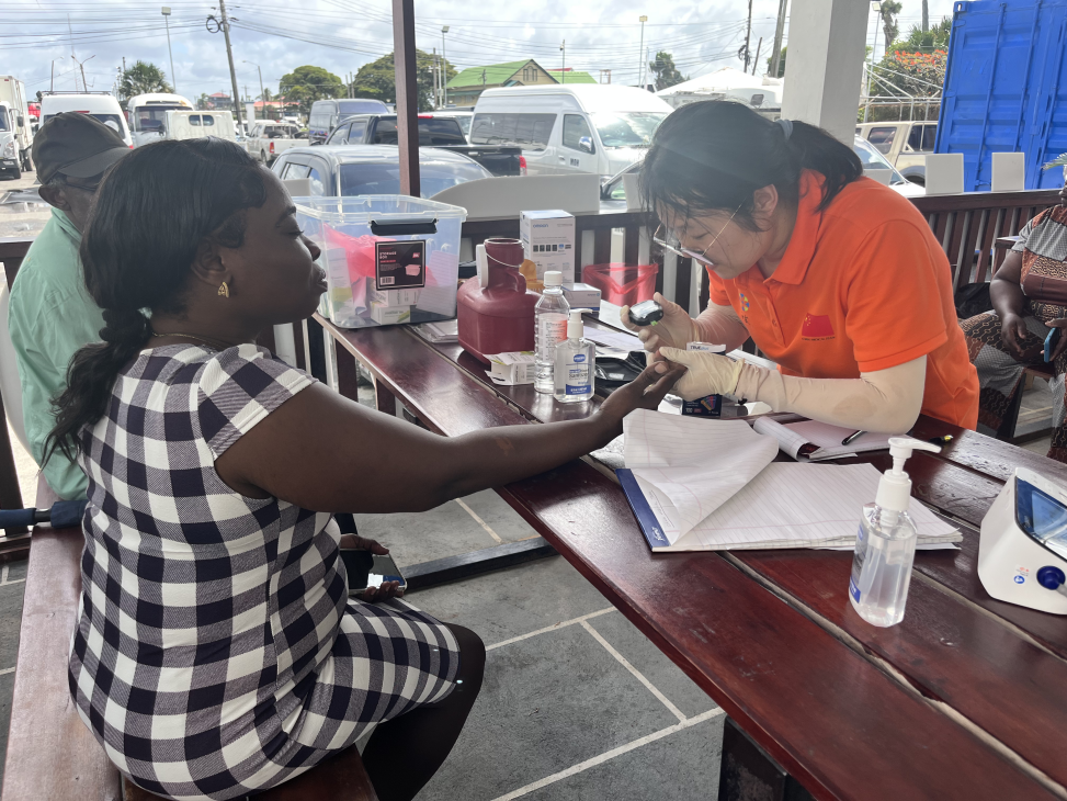 援圭亚那中国医疗队队员为当地民众进行血糖检测。第21批援圭亚那中国医疗队供图