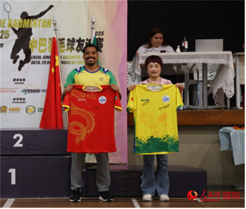 中国驻里约热内卢总领事田敏与里约米拉图斯羽毛球俱乐部球员代表多尼安斯·奥利维拉交换球衣。实习生 侯天泽摄