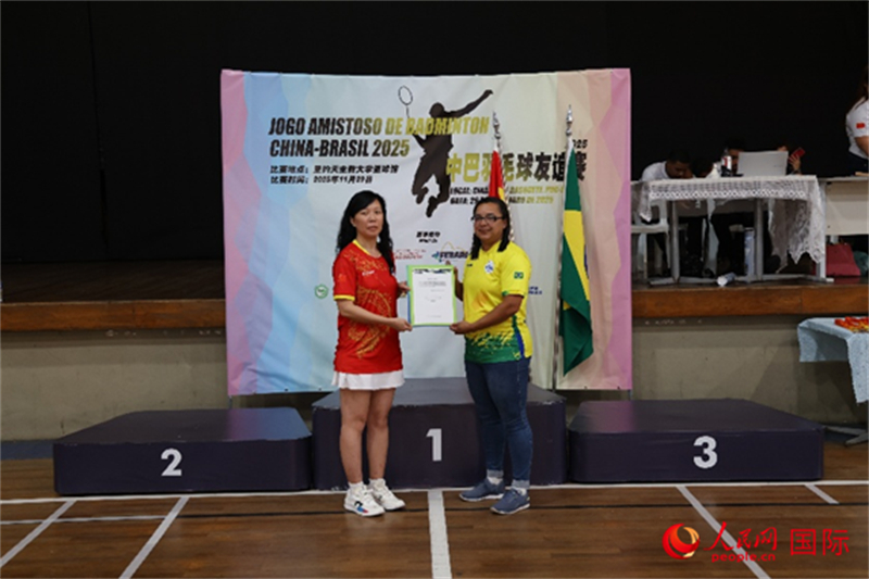 当地民间机构中巴体育运动联合会会长张颖与里约州羽毛球联合会主席西蒙尼展示签约文件。实习生 侯天泽摄