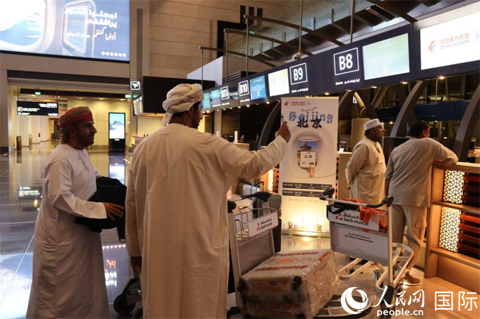 11月30日晚,在马斯喀特国际机场,准备前往北京的阿曼旅客正在办理值机手续。人民网记者 张志文摄