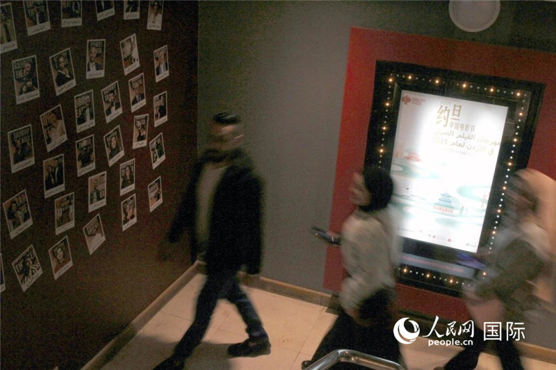 观众走过中国电影展示灯箱。人民网纳达尔·达乌德摄