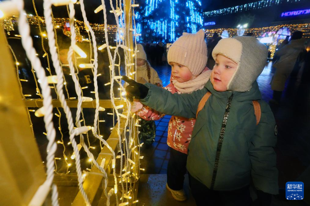 12月15日，在白俄罗斯明斯克，孩子们观看灯饰。新华社发（任科夫摄）