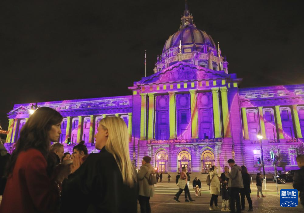 12月16日，人们在美国旧金山市政厅外观赏灯光秀。新华社发（刘艺霖摄）