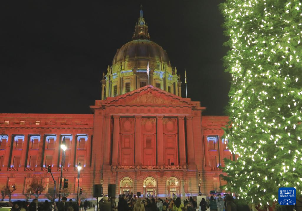 12月16日，人们在美国旧金山市政厅外观赏灯光秀。新华社发（刘艺霖摄）