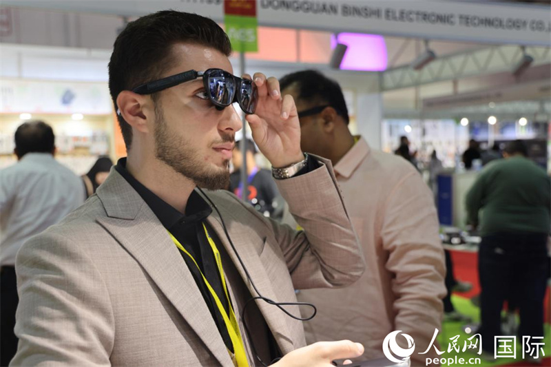 阿联酋联展上,叙利亚客商体验AI眼镜。人民网记者 张志文摄