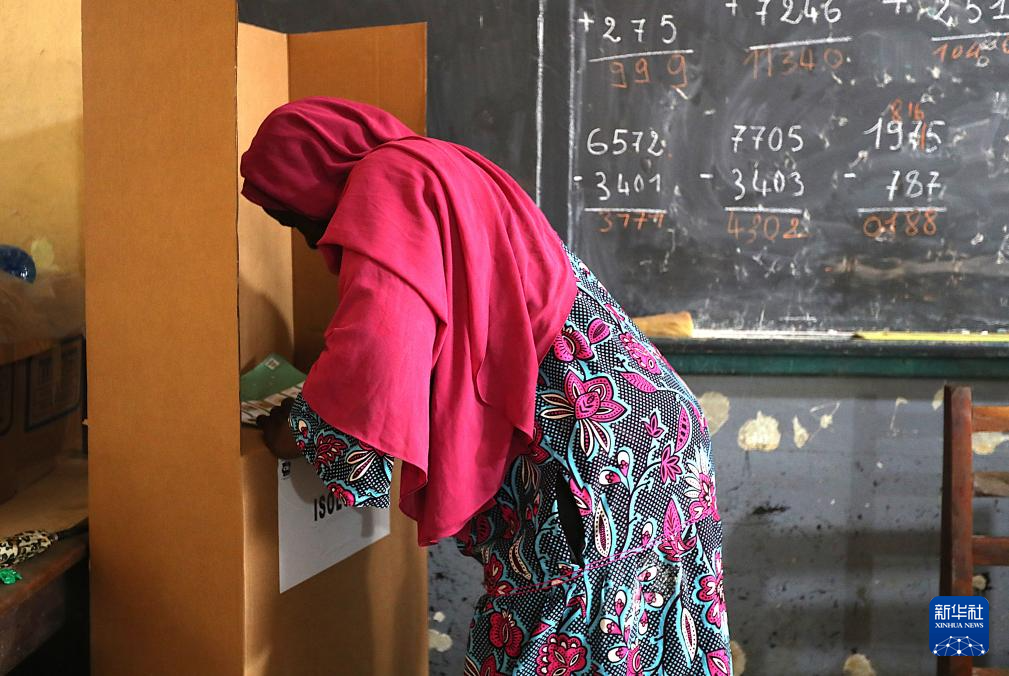 12月27日，一名选民在科特迪瓦经济首都阿比让的一处投票站填写选票。新华社发（伊万·宋摄）