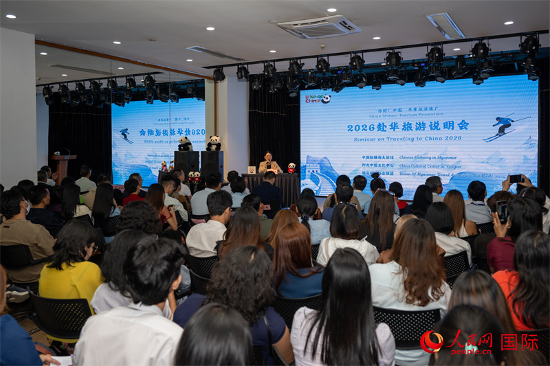 图二：中国驻缅甸大使馆工作人员介绍赴华旅游签证办理事宜。人民网记者 谢佳君摄