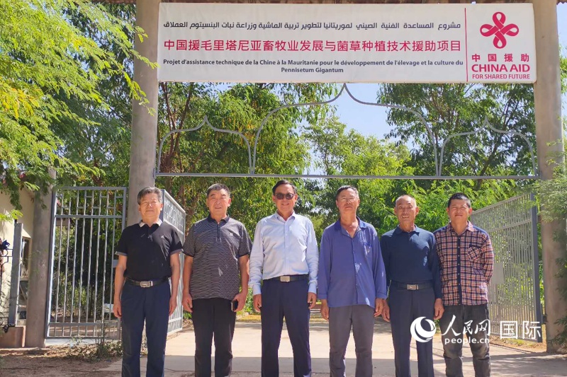 中国专家在项目大门前合影留念 人民网记者黄培昭摄