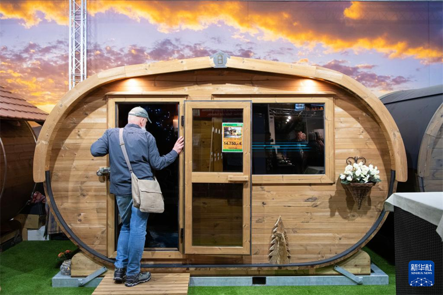 1月16日，在德国首都柏林，一名男子在柏林国际绿色周现场参观一款桑拿木屋产品。新华社记者 张豪夫 摄