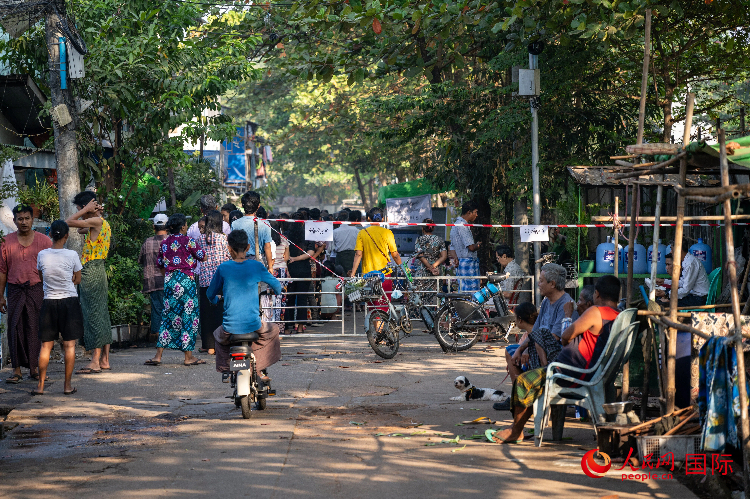 1月25日，选民在仰光某街道设立的投票站前排队投票。人民网记者 谢佳君摄