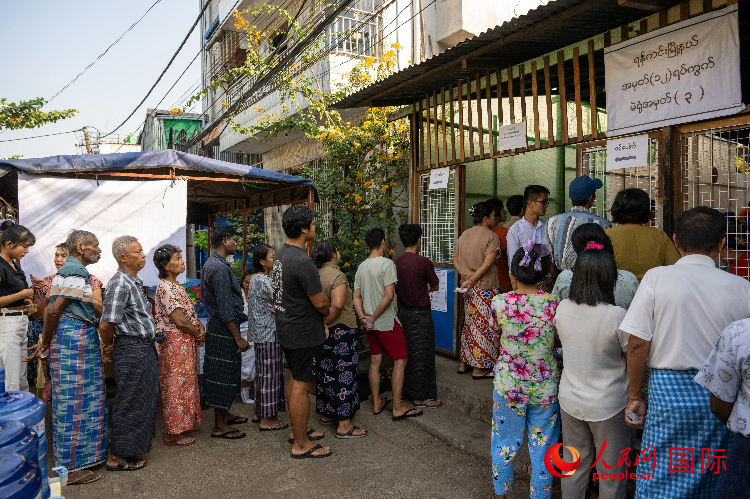 1月25日，选民在仰光某街区投票站入口处等待入场投票。人民网记者 谢佳君摄